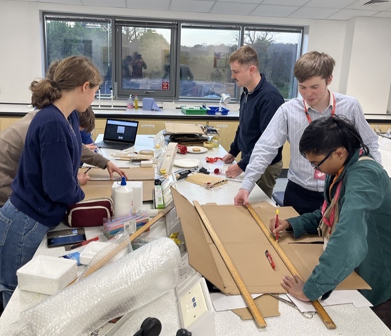 Students building the first cardboard prototype scroll pump for a leak detection unit